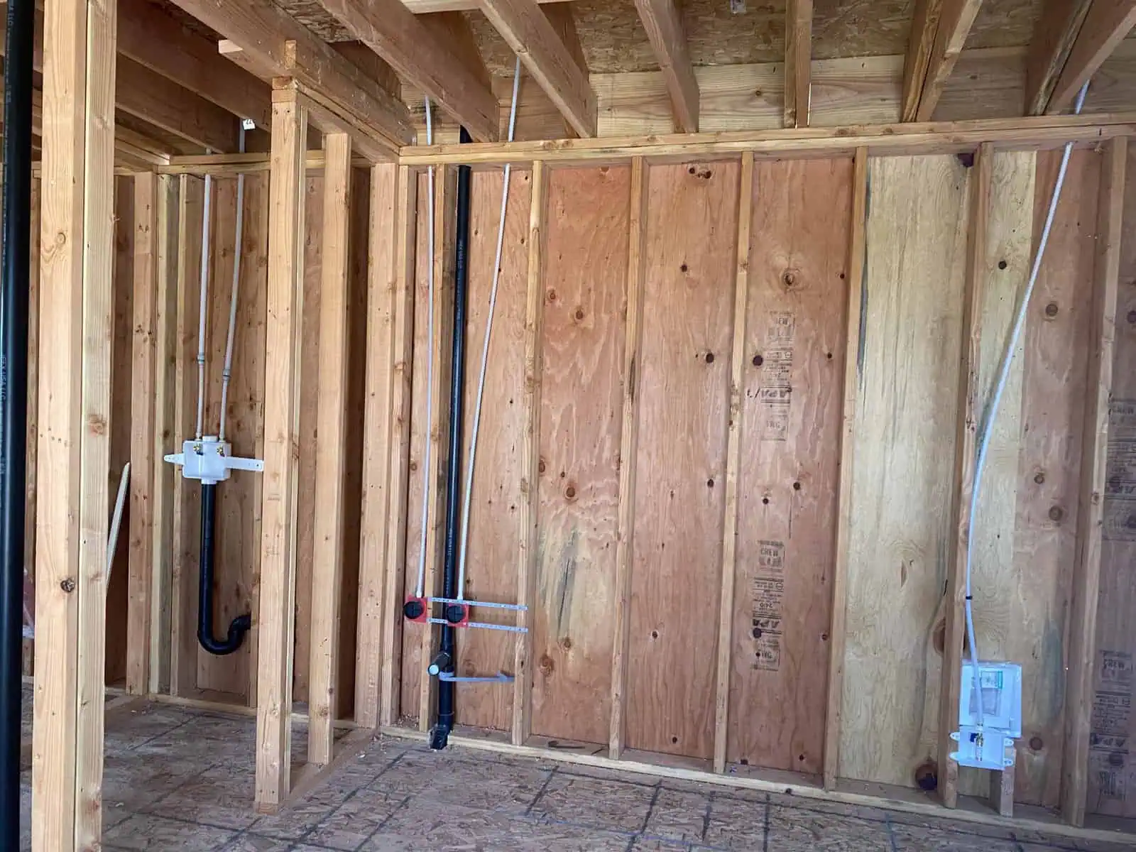 Plumbing pipes and electrical wiring installed in a new house construction.